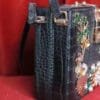 A black purse with some flowers on it