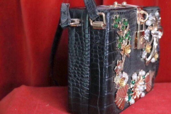 A black purse with some flowers on it