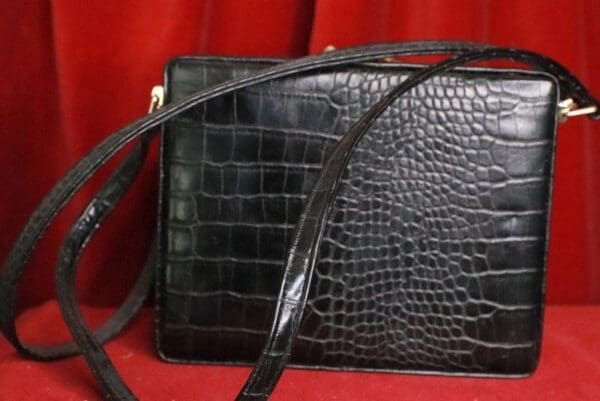 A black purse sitting on top of a red table.
