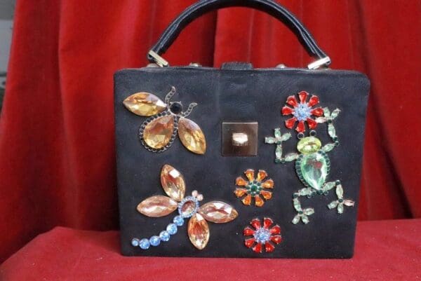 A black purse with some colorful designs on it