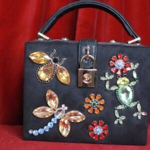 A black purse with various designs on it.