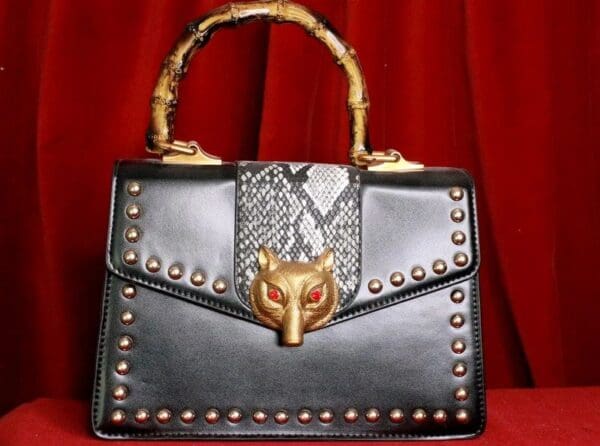 A black purse with gold and red accents.