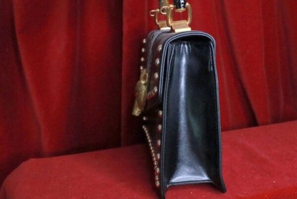 A black purse sitting on top of a red table.