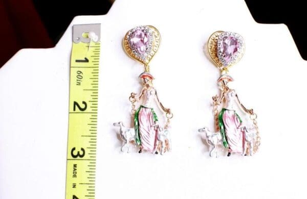 A pair of earrings with a ruler and a picture