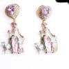A pair of earrings with a woman and two animals.