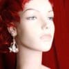 A mannequin with red hair and white earrings.