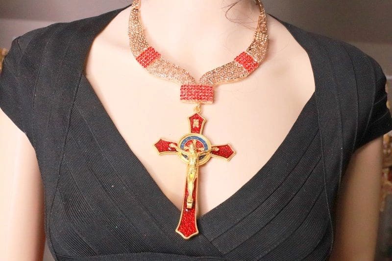 A woman wearing a necklace with a cross on it.