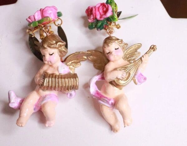 Two angels are sitting on a table with flowers.