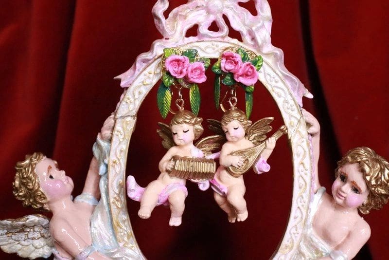 A picture of two angels hanging from the side of a mirror.