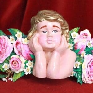 A statue of a child with flowers around it.