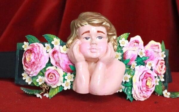 A statue of a child with flowers around it.