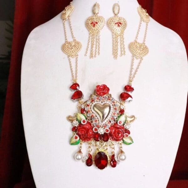 A necklace and earrings set with red flowers.