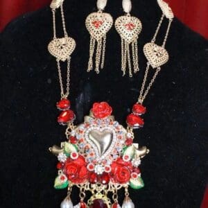 A necklace and earrings set with red roses.