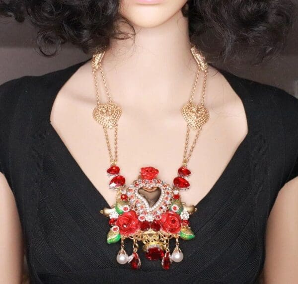 A woman wearing a necklace with red roses.