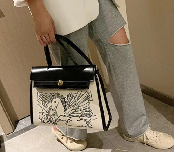 A person holding onto a bag with a bird on it