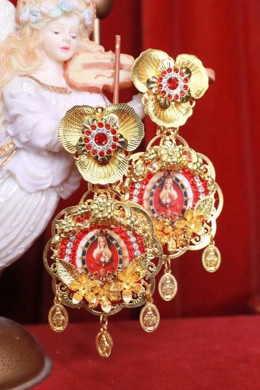 A pair of earrings with gold and red designs.