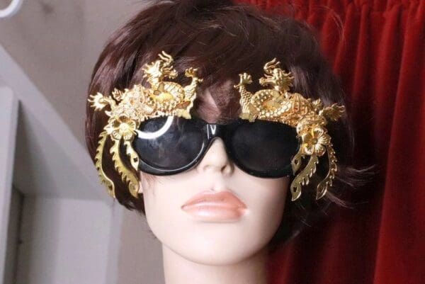 A woman wearing sunglasses with gold decorations on them.