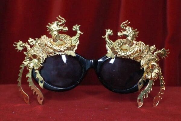 A pair of sunglasses with gold dragon heads on them.