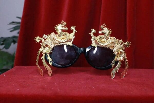 A pair of sunglasses with gold crabs on them.