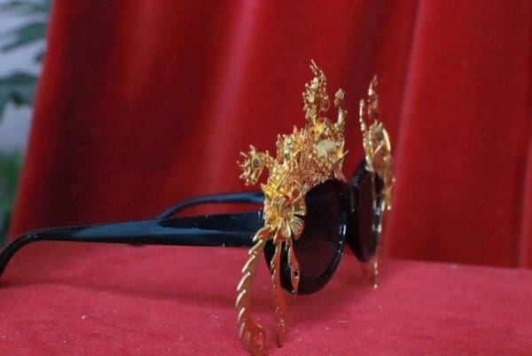 A gold hairpiece sitting on top of a red cloth.
