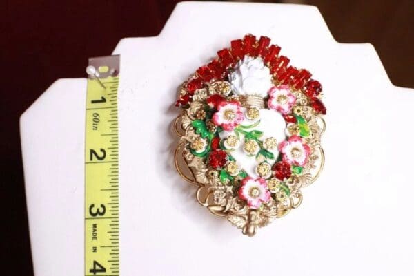 A white and red flower ornament on a table.