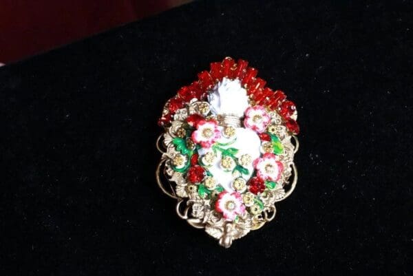A brooch with flowers and beads on it.