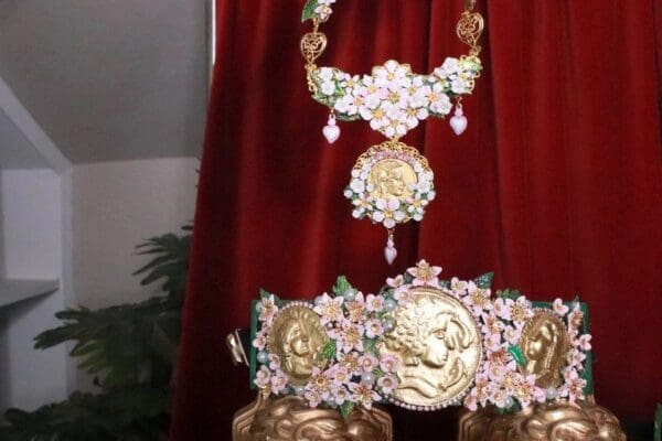 A red curtain with a gold and white necklace