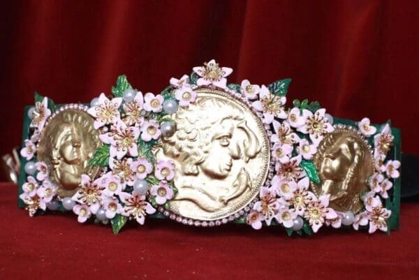 A gold and white flower decorated belt with a woman 's face on it.