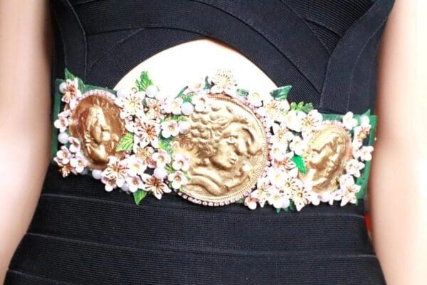 A close up of the head band with flowers and gold horses