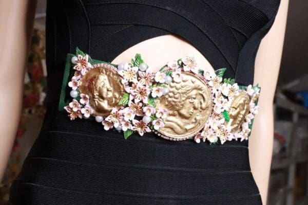 A close up of the belt with flowers and gold