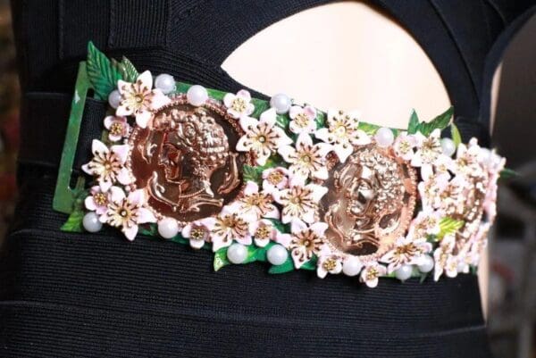 A close up of the flowers and coins on a headband