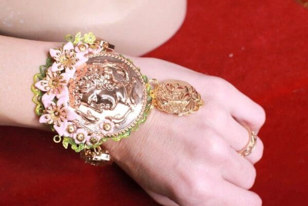 A woman 's hand with a bracelet and ring on it.