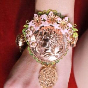 A woman wearing a bracelet with flowers and a coin.