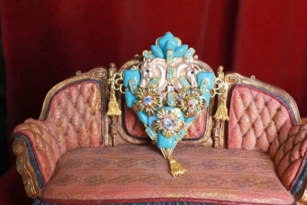 A close up of a chair with a blue and gold ornament