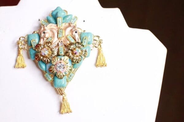 A brooch with tassels and flowers on it.