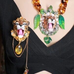 A woman wearing jewelry with a leopard face on it.