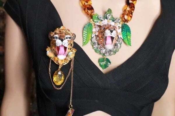 A woman wearing jewelry with a leopard face on it.