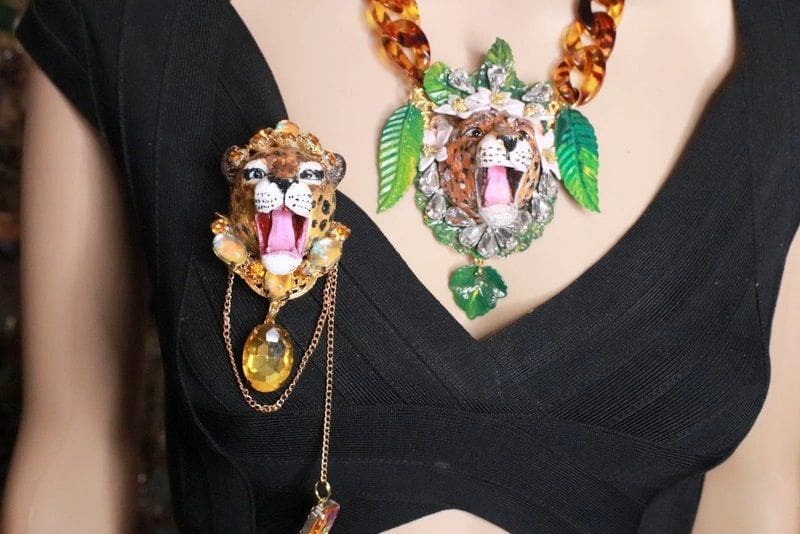 A woman wearing jewelry with a leopard face on it.