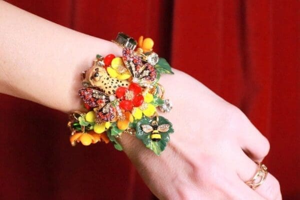 A woman wearing a bracelet with flowers on it.