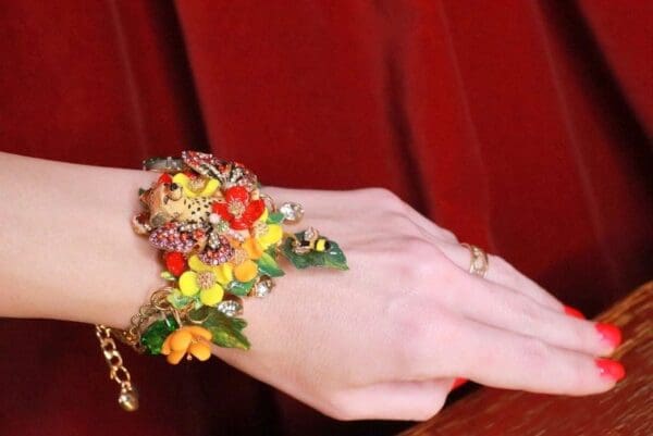 A woman wearing a bracelet with flowers on it.