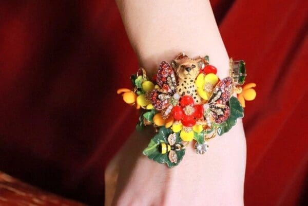 A woman wearing a bracelet with flowers on it.