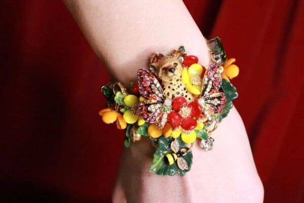A woman wearing a bracelet with flowers on it.