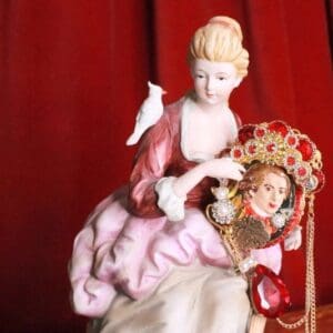 A porcelain figurine of a woman and a doll.