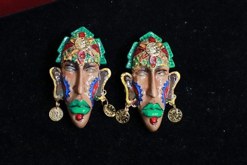 A pair of colorful face earrings with gold coins.