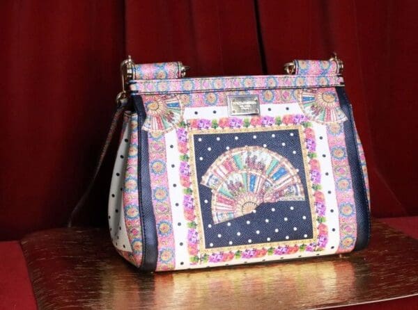 A purse with a fan design on it sitting on top of a table.