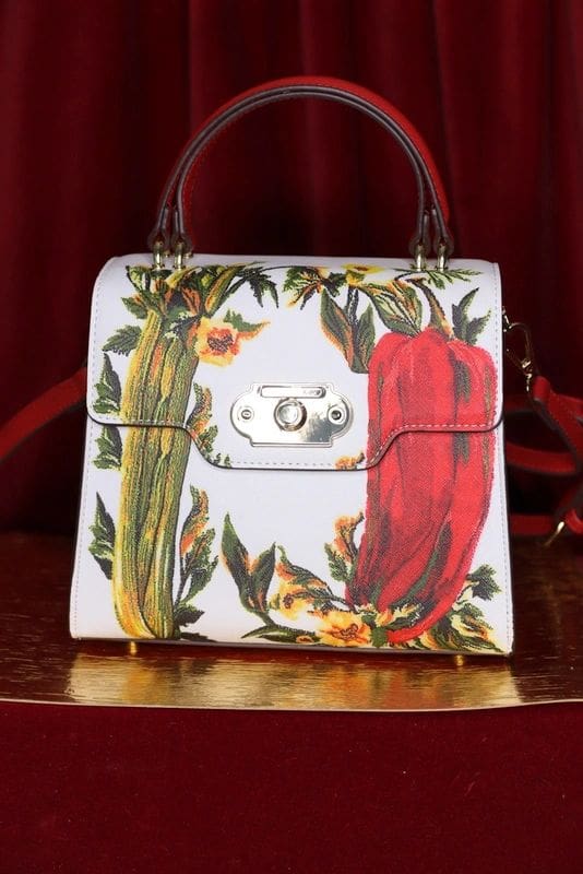 A white purse with red and green peppers on it.