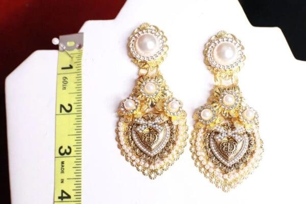 A pair of earrings with a measuring tape on the side.