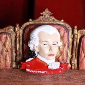 A ceramic head of mozart sitting in front of two chairs.
