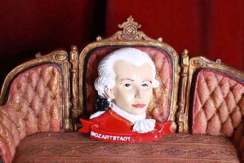 A ceramic head of mozart sitting in front of two chairs.