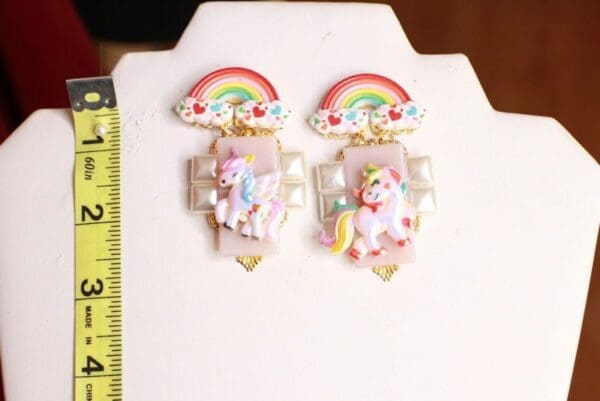 A pair of unicorn earrings sitting on top of a table.